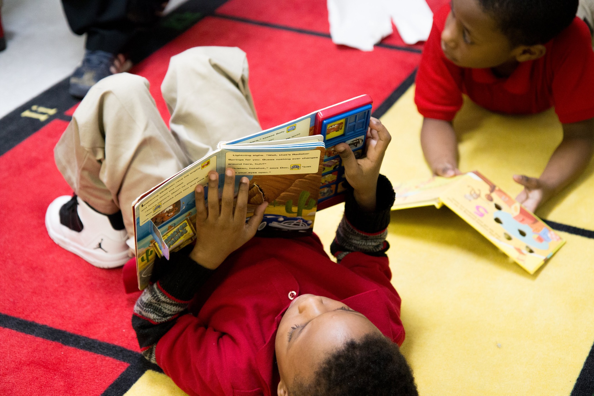 Scholar Reading a book laying on the floor.